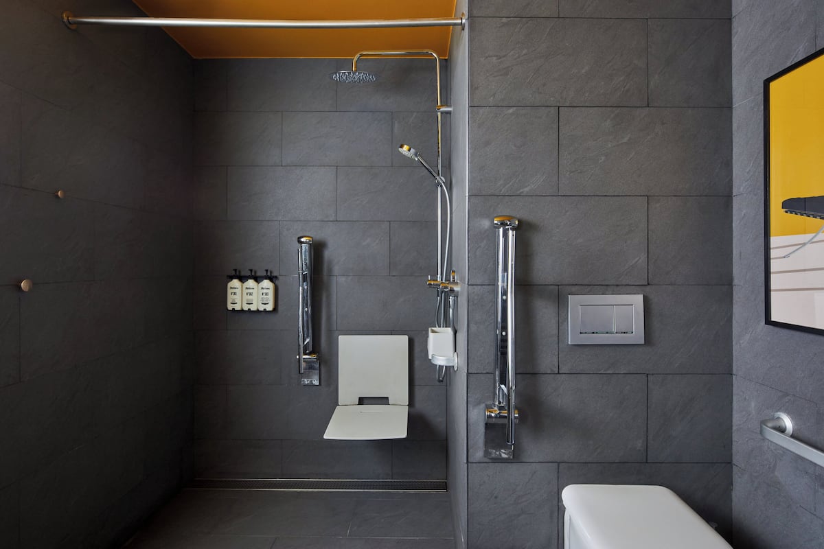 Un baño moderno con ducha, inodoro y toallero.