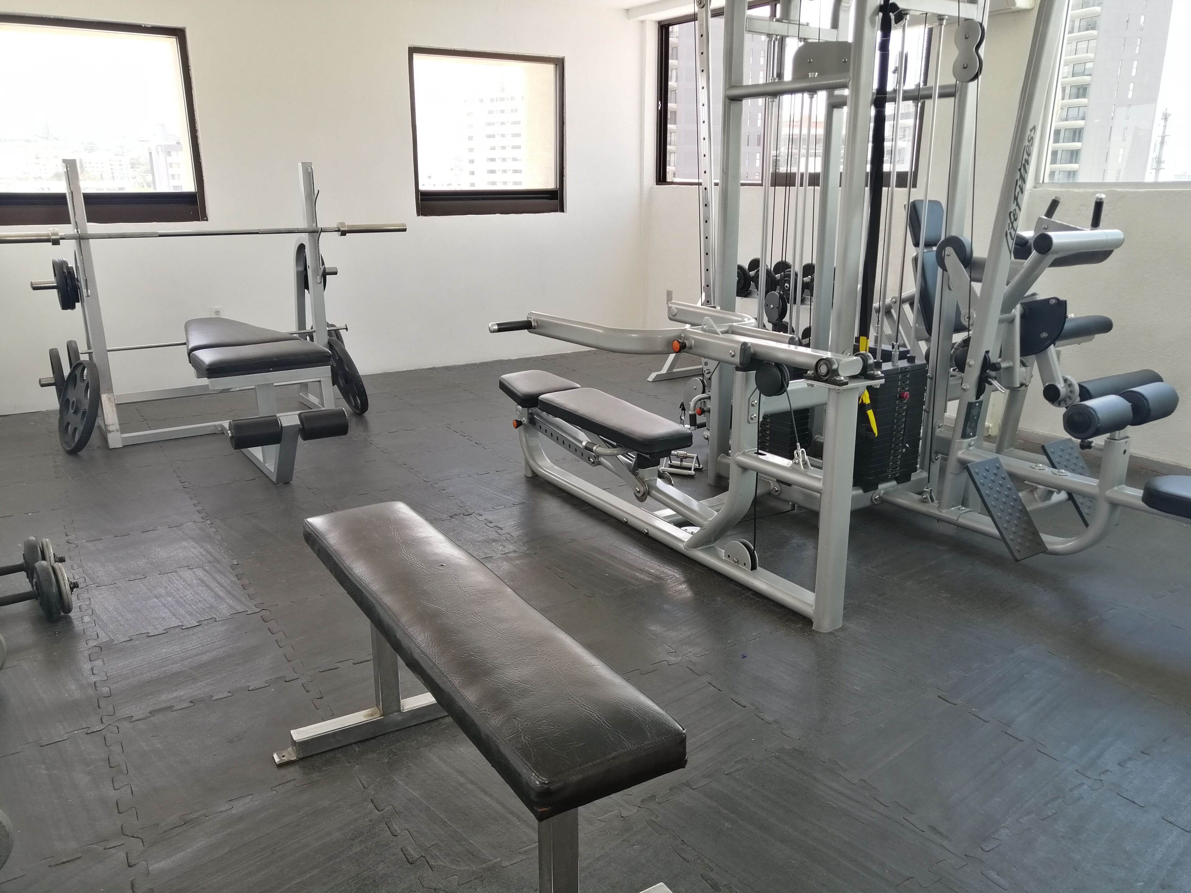 A gym with various exercise equipment, including benches and weight machines.