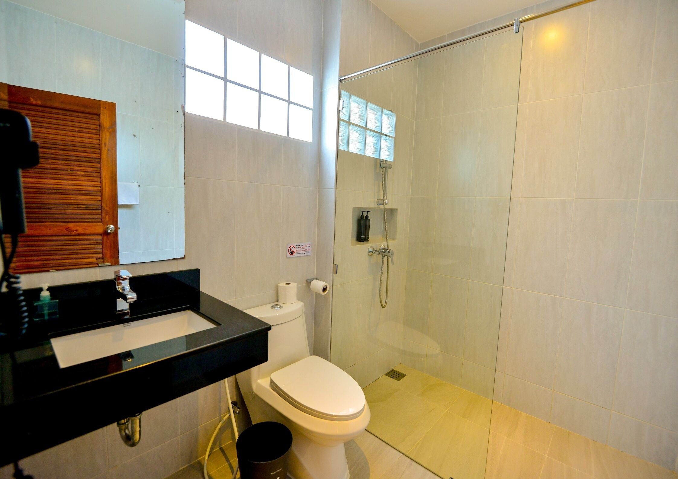 A modern bathroom with a toilet, sink, and glass-enclosed shower.