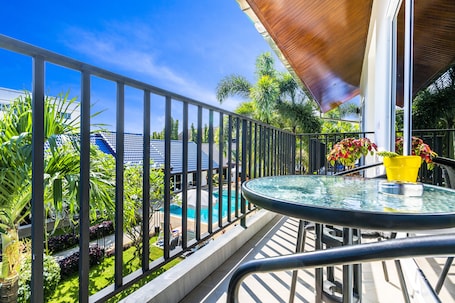 Una piscina al aire libre, sombrillas, sillones reclinables de piscina