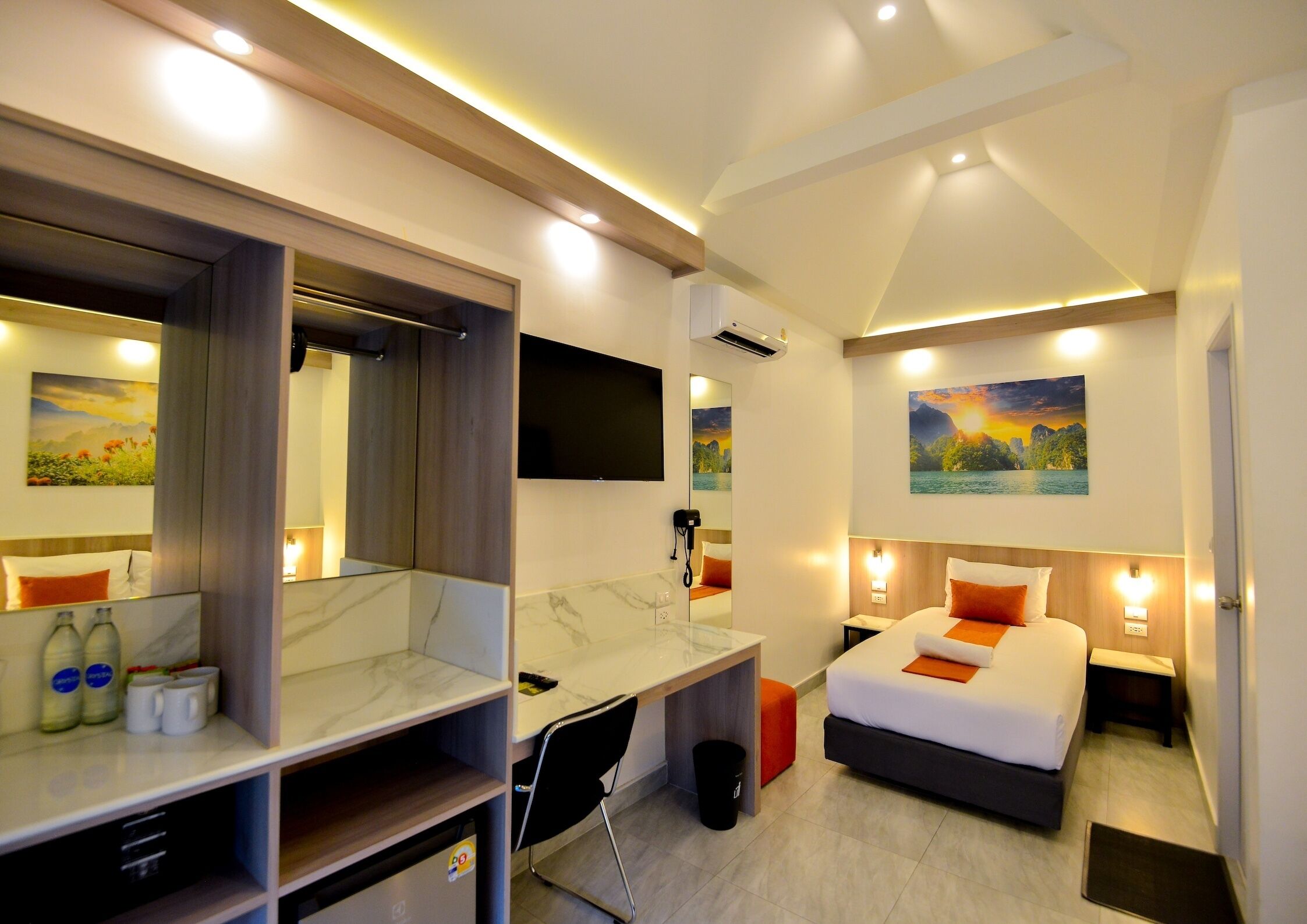 A modern hotel room with a bed, desk, and seating area.