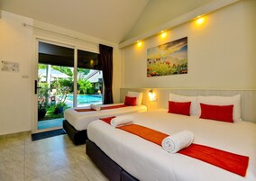 Habitación de hotel con dos camas, un cuadro y vistas a una piscina.