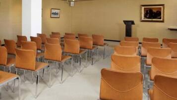 A conference room with rows of chairs and a podium.