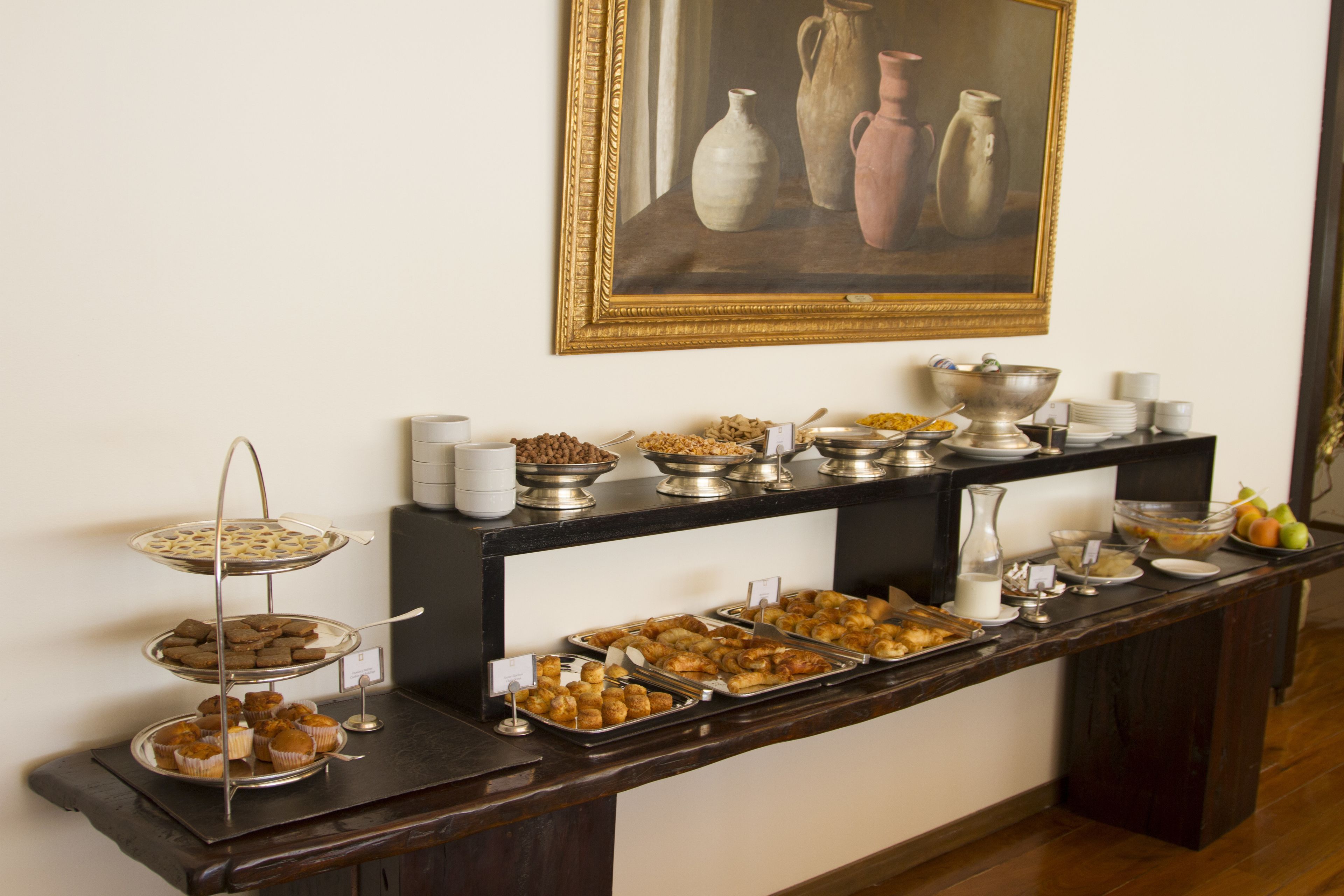 Un buffet garni de divers plats et un tableau accroché au mur.