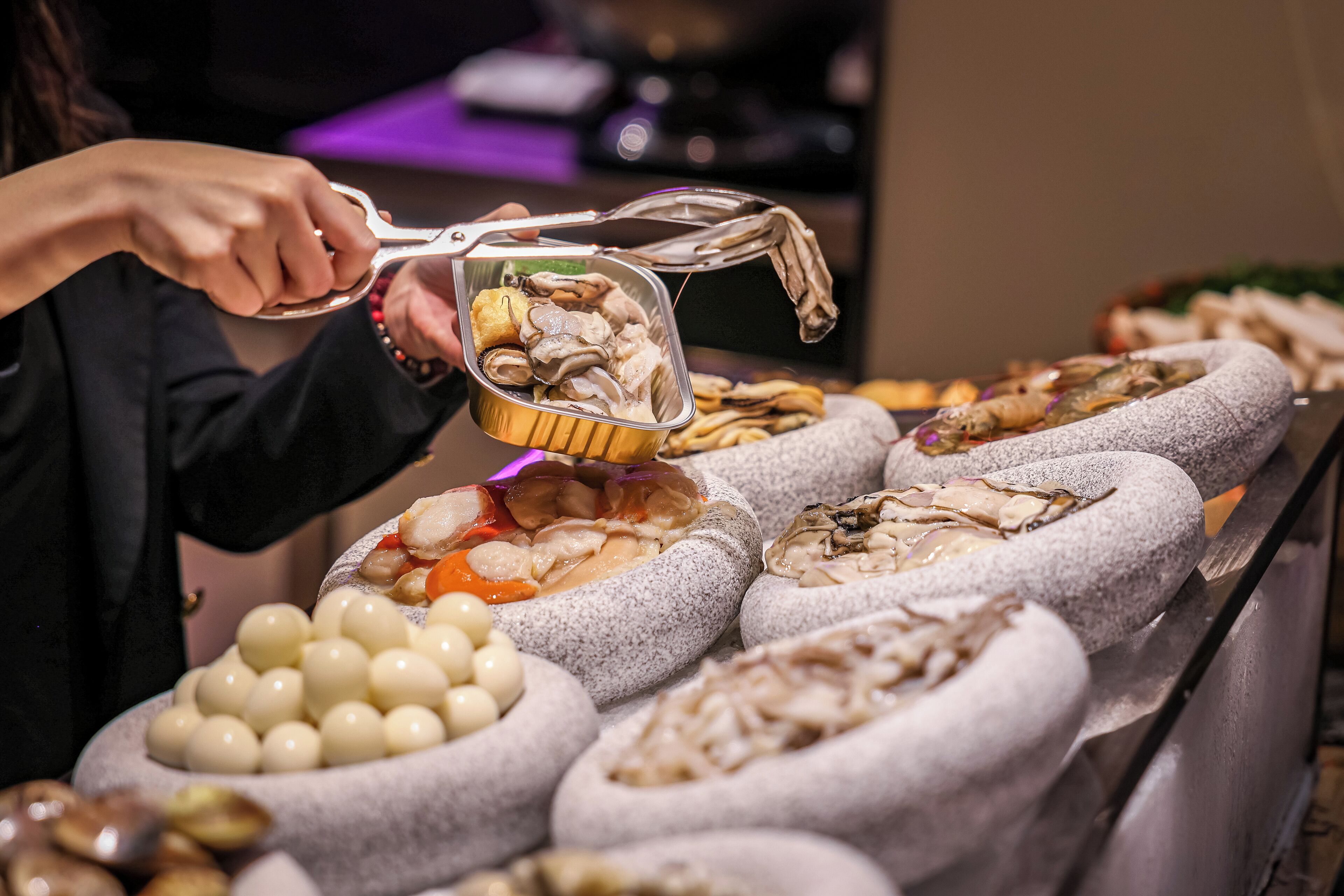 Un buffet proposant une variété de plats, notamment des fruits de mer, des légumes et d’autres mets.