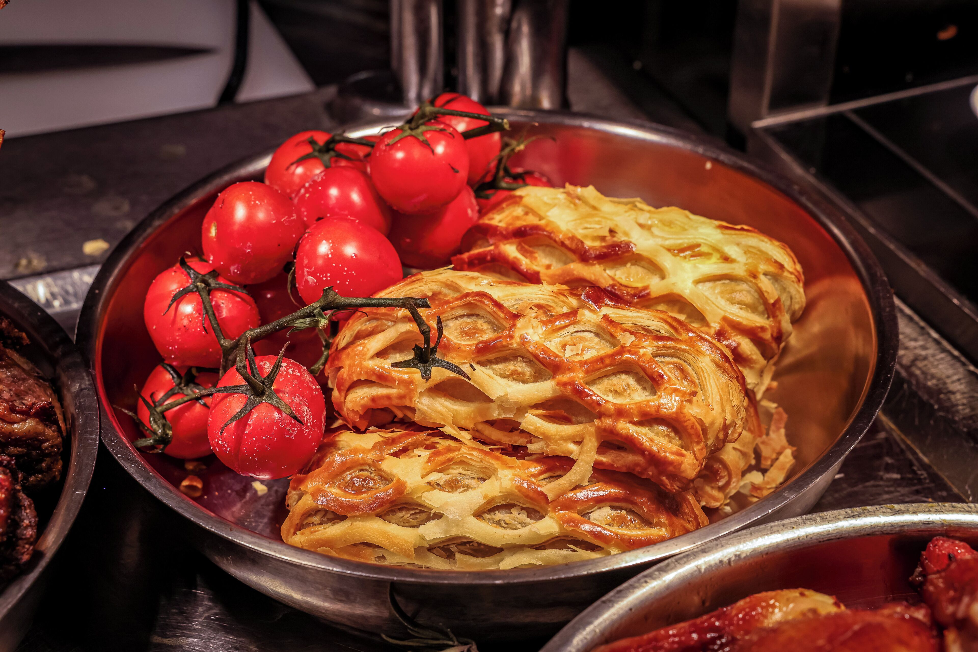 A dish with tomatoes and a baked pastry.