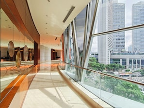 Un interior moderno con barandilla de vidrio que da a vistas de la ciudad.