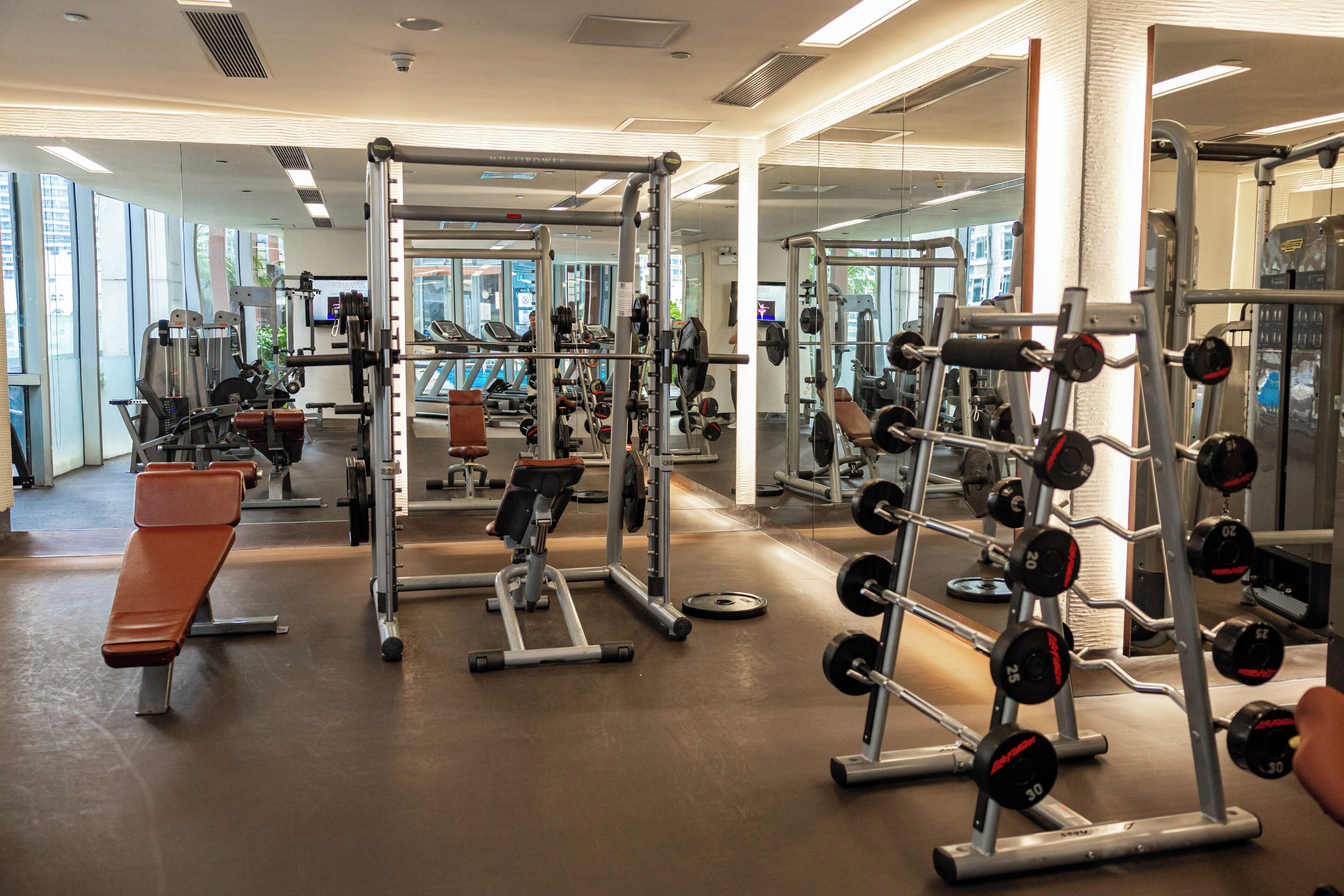Un gimnasio con diversos equipos de ejercicio, incluyendo máquinas de pesas y pesas libres.