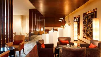 A lobby with seating arrangements, a reception desk, and artwork on the walls.