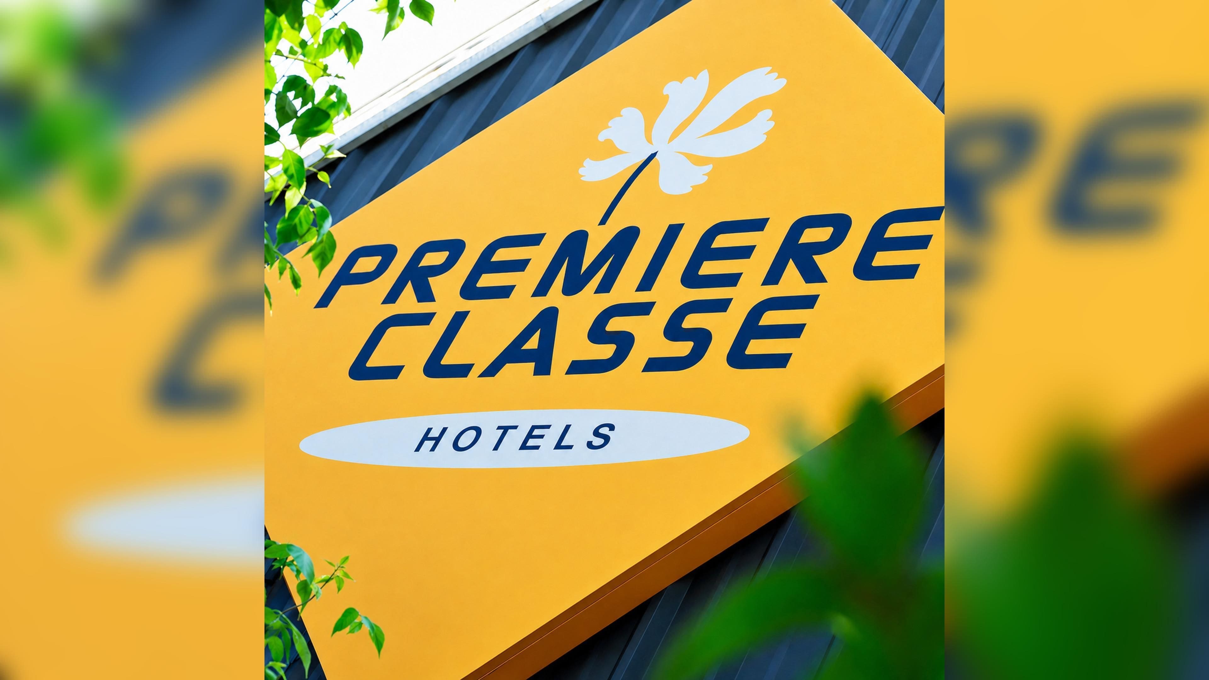 Un letrero con el texto 'PREMIERE CLASSE HOTELS' y un logotipo con un diseño floral estilizado.