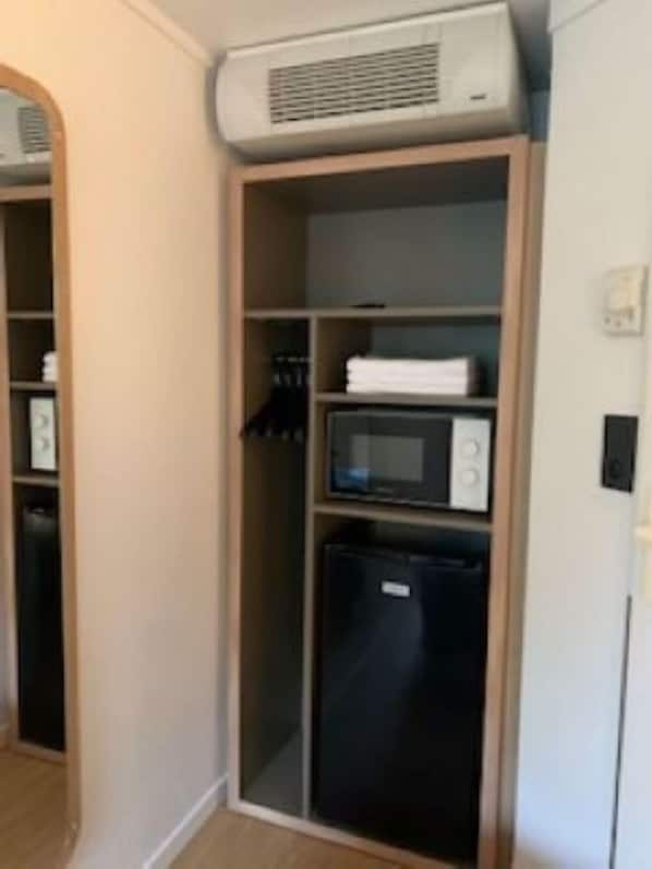 A compact kitchenette with a microwave, refrigerator, and built-in oven. - Premiere Classe Compiègne - Jaux (Jaux)