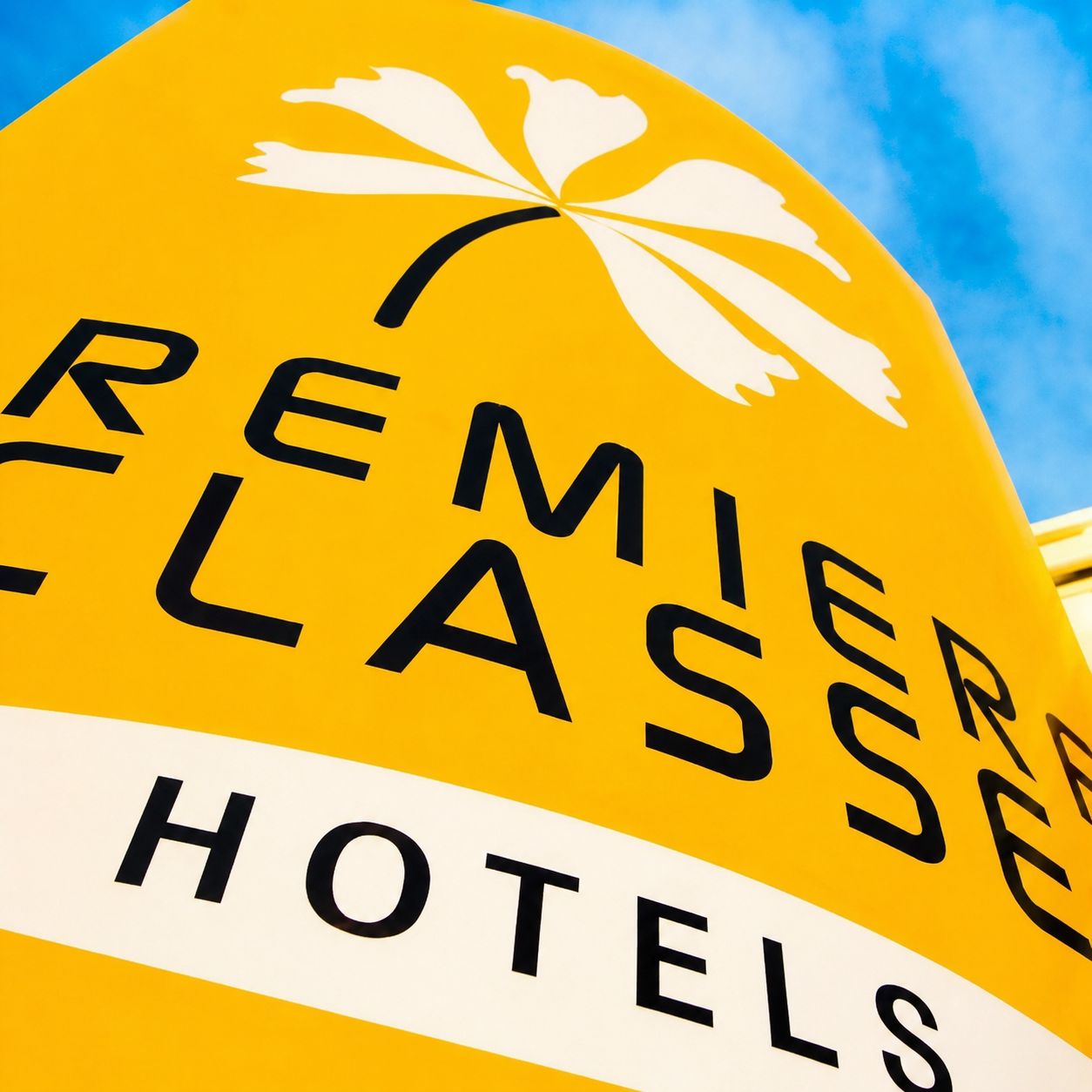 A yellow sign with 'REMIER CLASSE HOTELS' written on it.