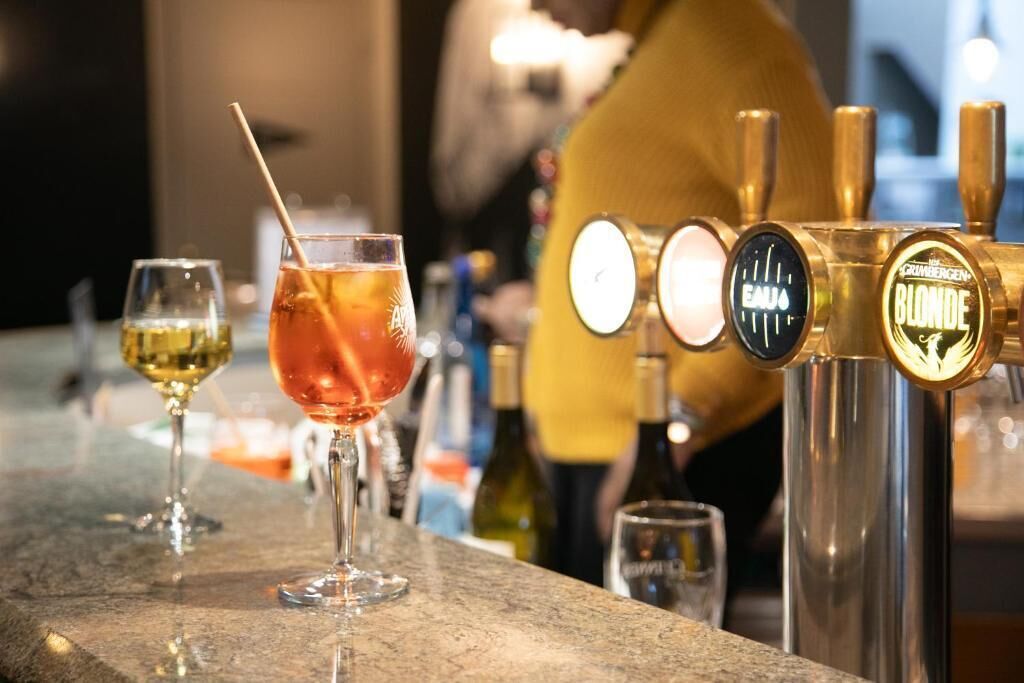 Zona de bar con vasos de bebidas y un grifo con la leyenda 'Blonde'.