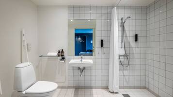 A modern bathroom with a toilet, sink, and shower.