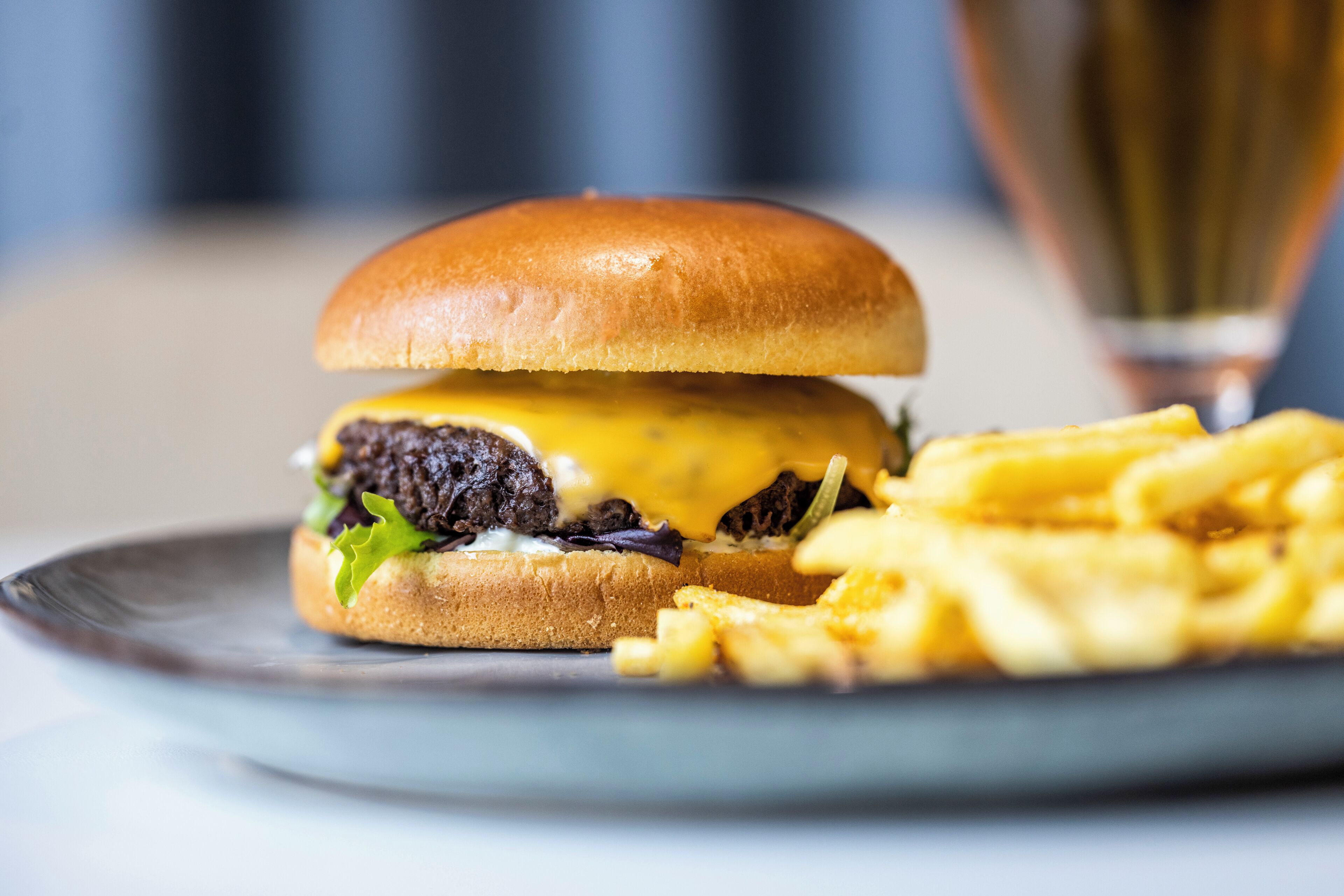 A burger with fries on a plate.