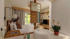 A hotel room with a bed, bedside table, mirror, TV, sink, and potted plant.