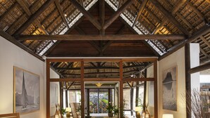A spacious lobby with a wooden ceiling, seating areas, and artwork on the walls.