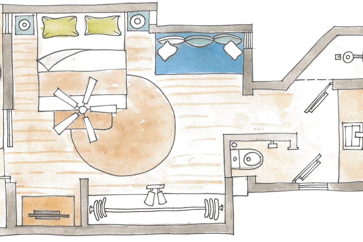 A room with a bed, a fan, a window, a sink, and a mirror.
