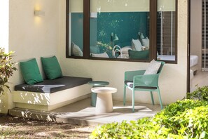 A sunlit outdoor seating area with a sofa, two chairs, and a small table. - Coin de Mire Attitude (Cap Malheureux)