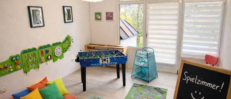 Une pièce avec une table de baby-foot, un jeu d’échecs et une table de baby-foot ornée du logo d’un panda.