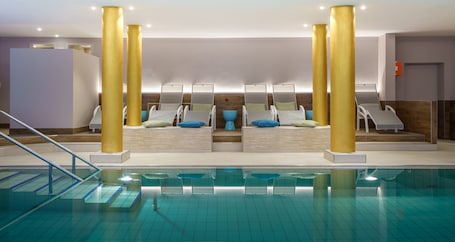 Una piscina techada, sillones reclinables de piscina