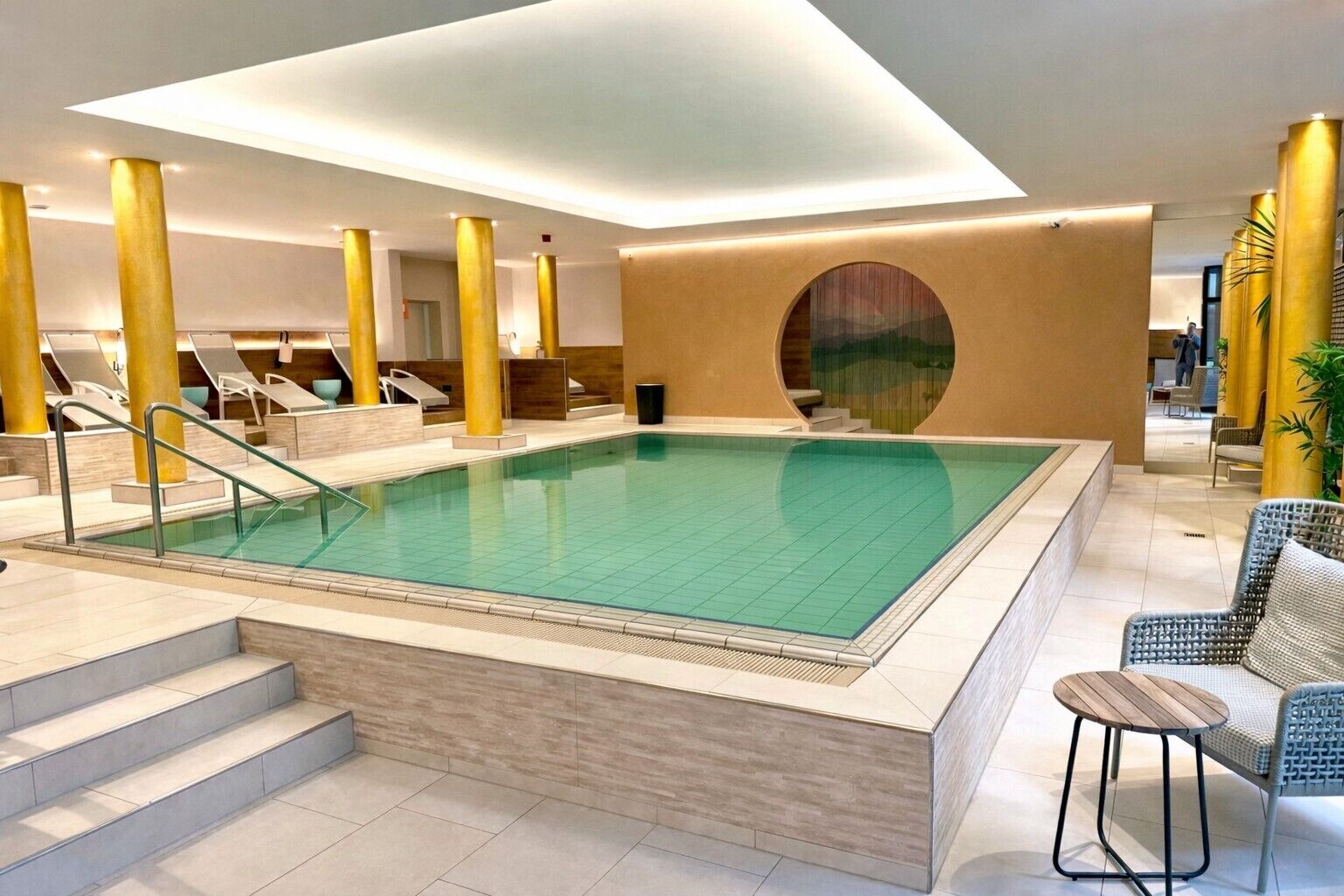 Una piscina techada, sillones reclinables de piscina