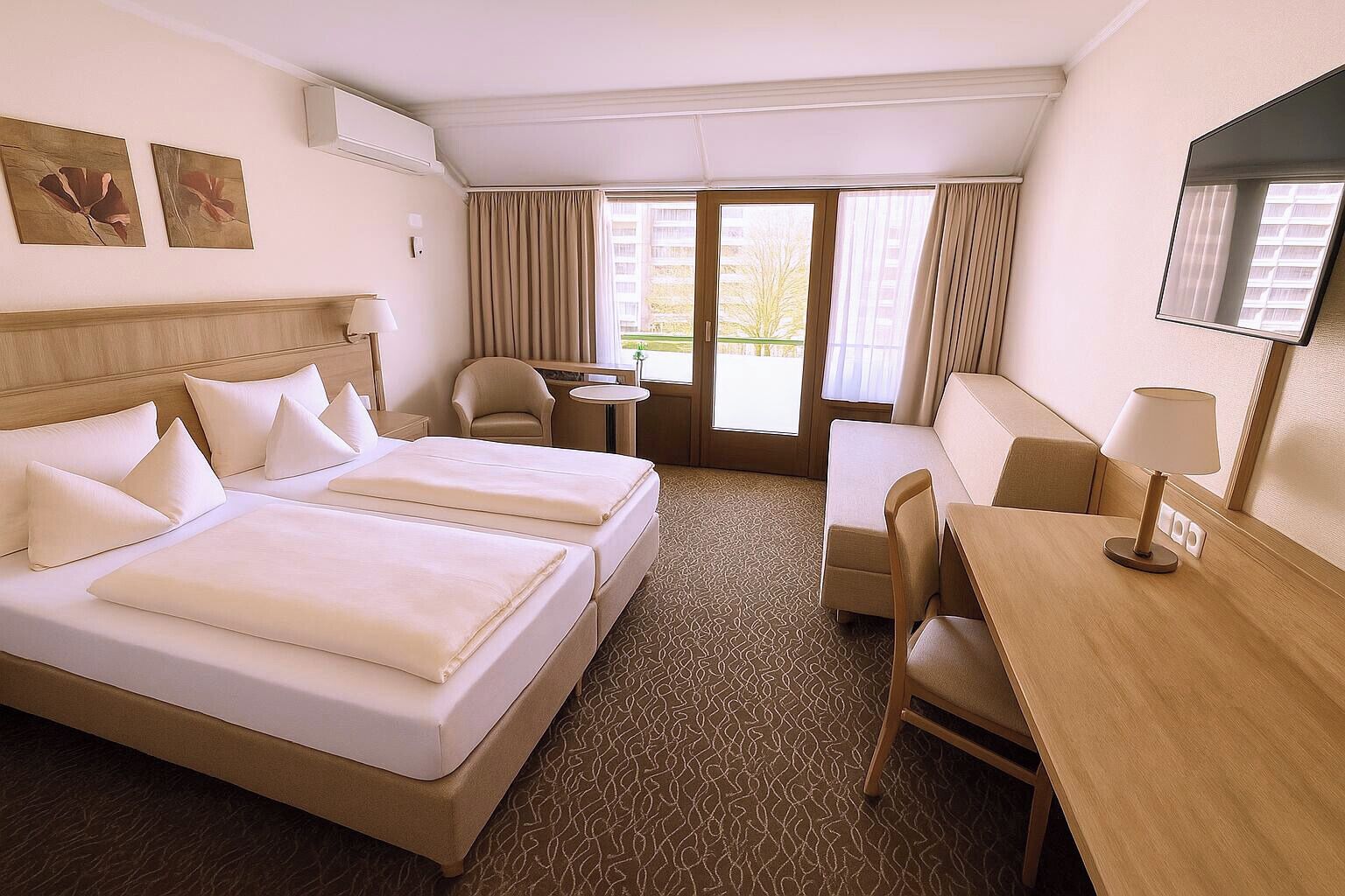 Habitación de hotel con dos camas, un escritorio, una silla, una mesita y una ventana con cortinas.