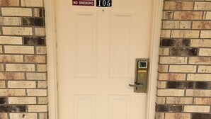 A white door with a "NO SMOKING" sign and the number "105" above it. - Luxury Inn & Suites Forrest City (Forrest City)