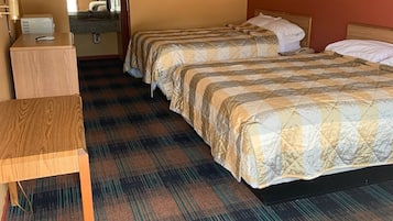 A hotel room with two beds, a desk, and a small kitchenette.