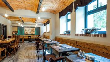 Un restaurante con techos de ladrillo, mesas y bancos de madera.