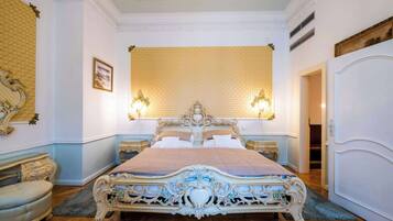 Una cama grande y ornamentada con un cabecero alto, dos lámparas de noche y un espejo grande sobre la cama.