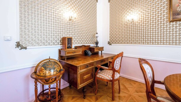 A room with a wooden desk, a globe, a chair, and a table. - Clarion Grandhotel Zlaty Lev (Liberec)