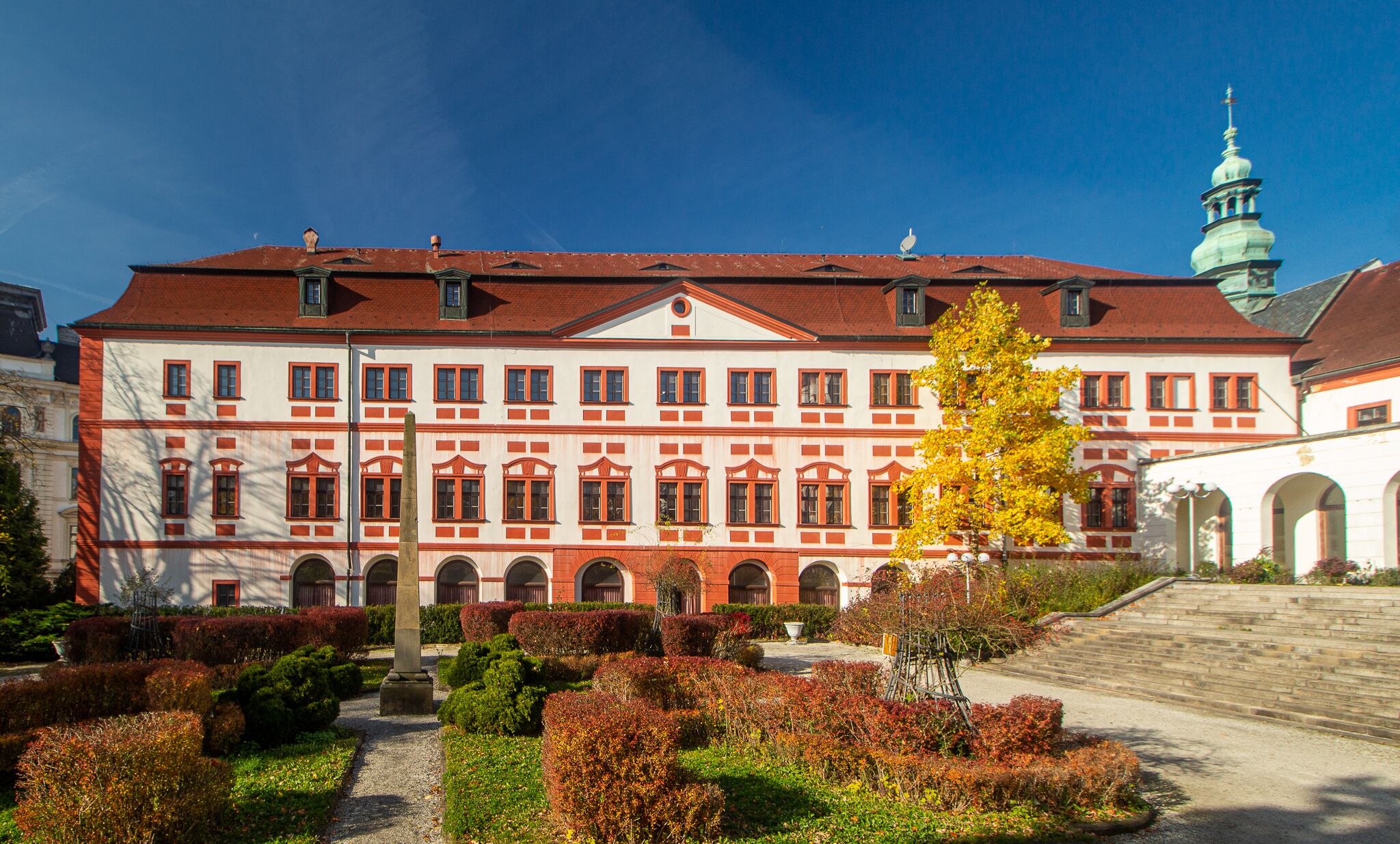 A large, historic building with a symmetrical facade, arched windows, and a central entrance.