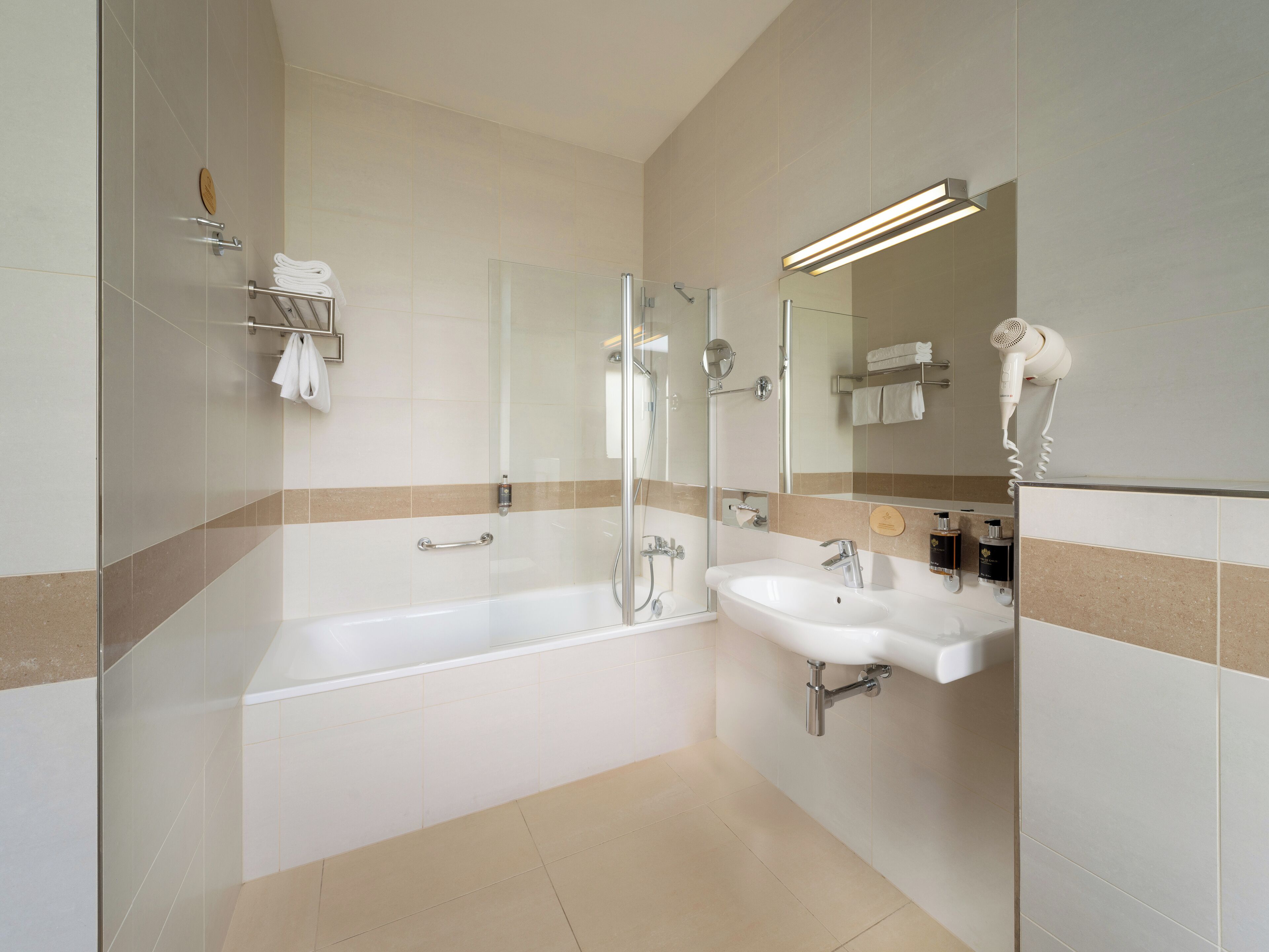Un bagno moderno con doccia vetrata, vasca freestanding e lavandino.