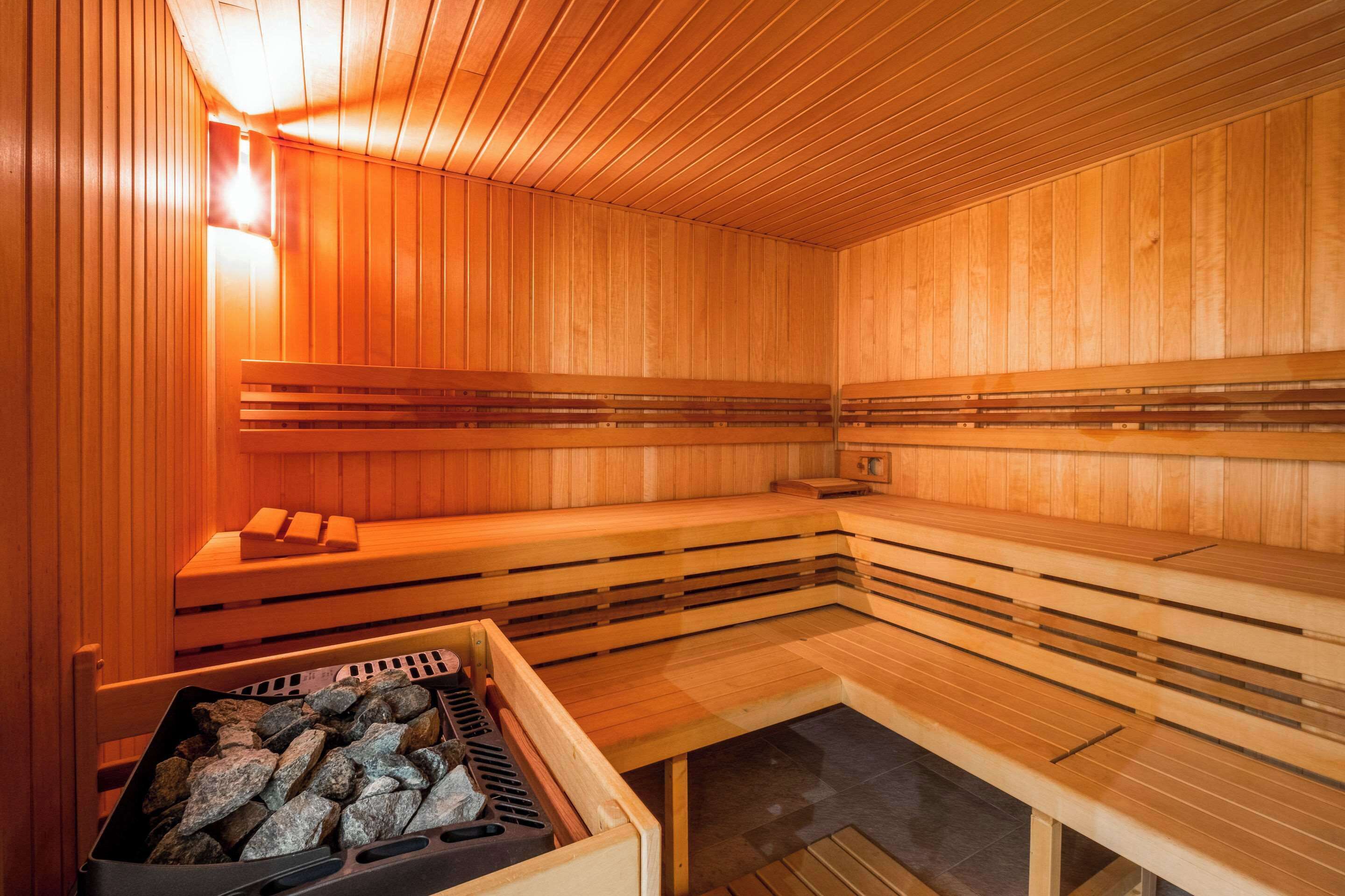 A sauna with wooden benches and a stone heating element.