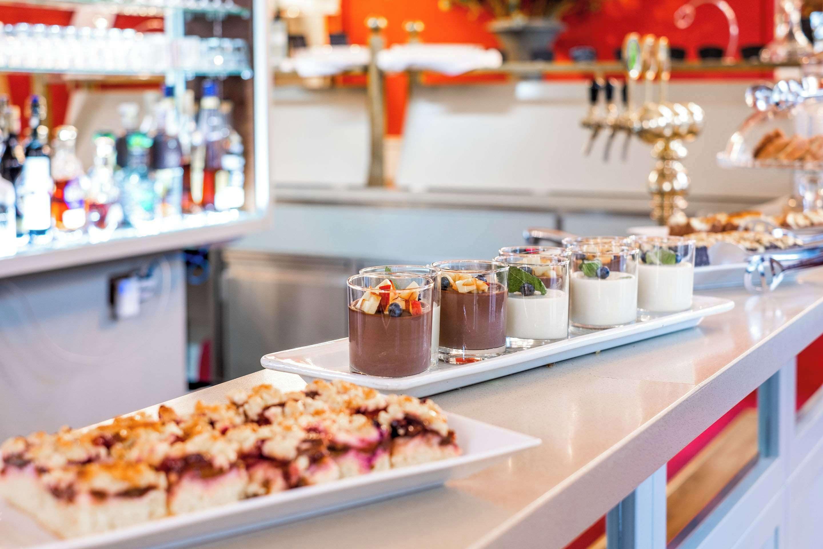 A bar area with a dessert tray and a selection of beverages.