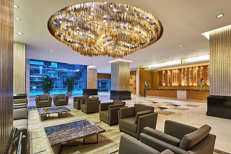 A spacious lobby with a large chandelier, seating area, and a reception desk.. Four Points by Sheraton Shanghai, Daning