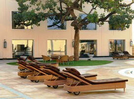 Una piscina al aire libre, sillones reclinables de piscina