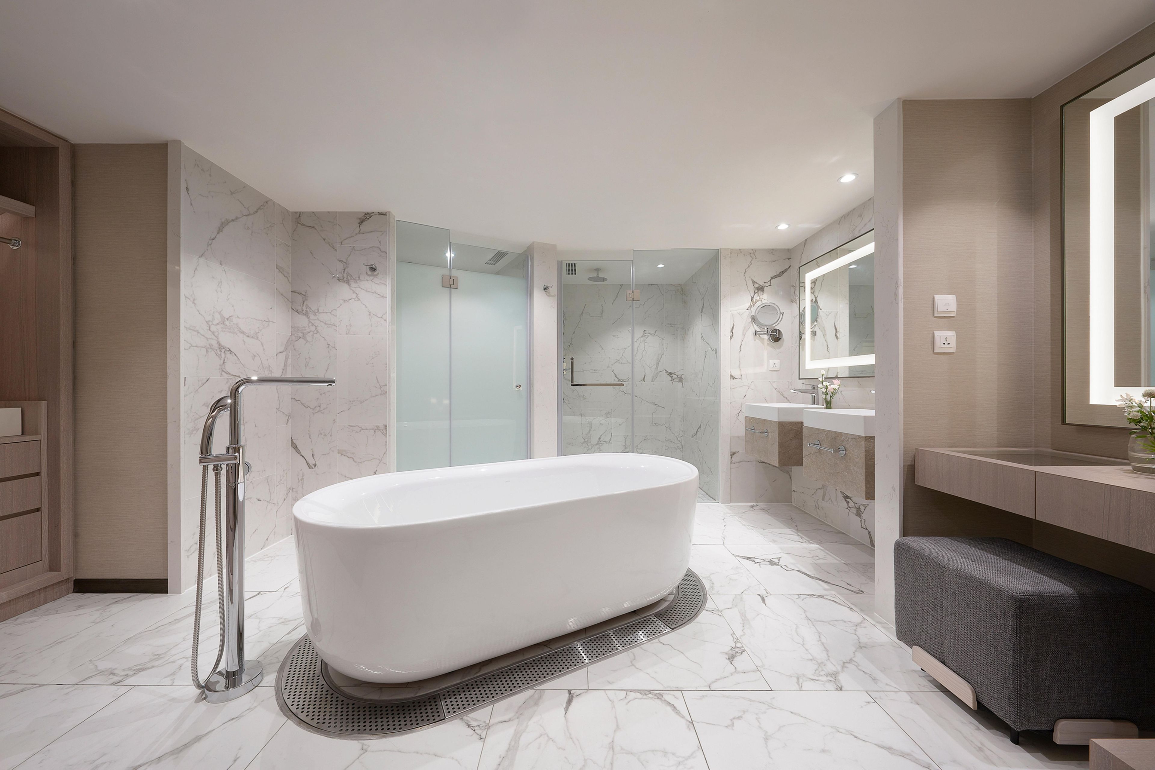 A modern bathroom with a freestanding bathtub, a glass-enclosed shower, and a vanity with a mirror.