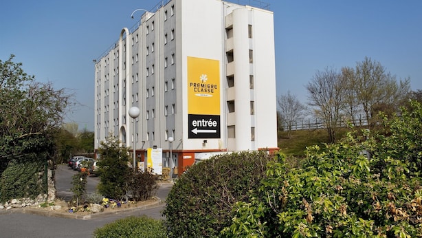 Un hotel de varios pisos con un letrero de entrada llamativo.