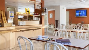 Un restaurante con mostrador, sillas y mesas.