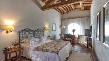 A bedroom with a bed, bedside lamps, a desk, and a chair.