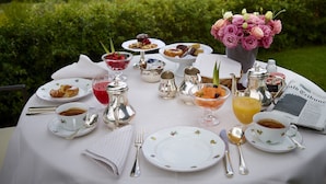 A table set for breakfast with various dishes, drinks, and a newspaper. - Hotel Le Fontanelle (Castelnuovo Berardenga)