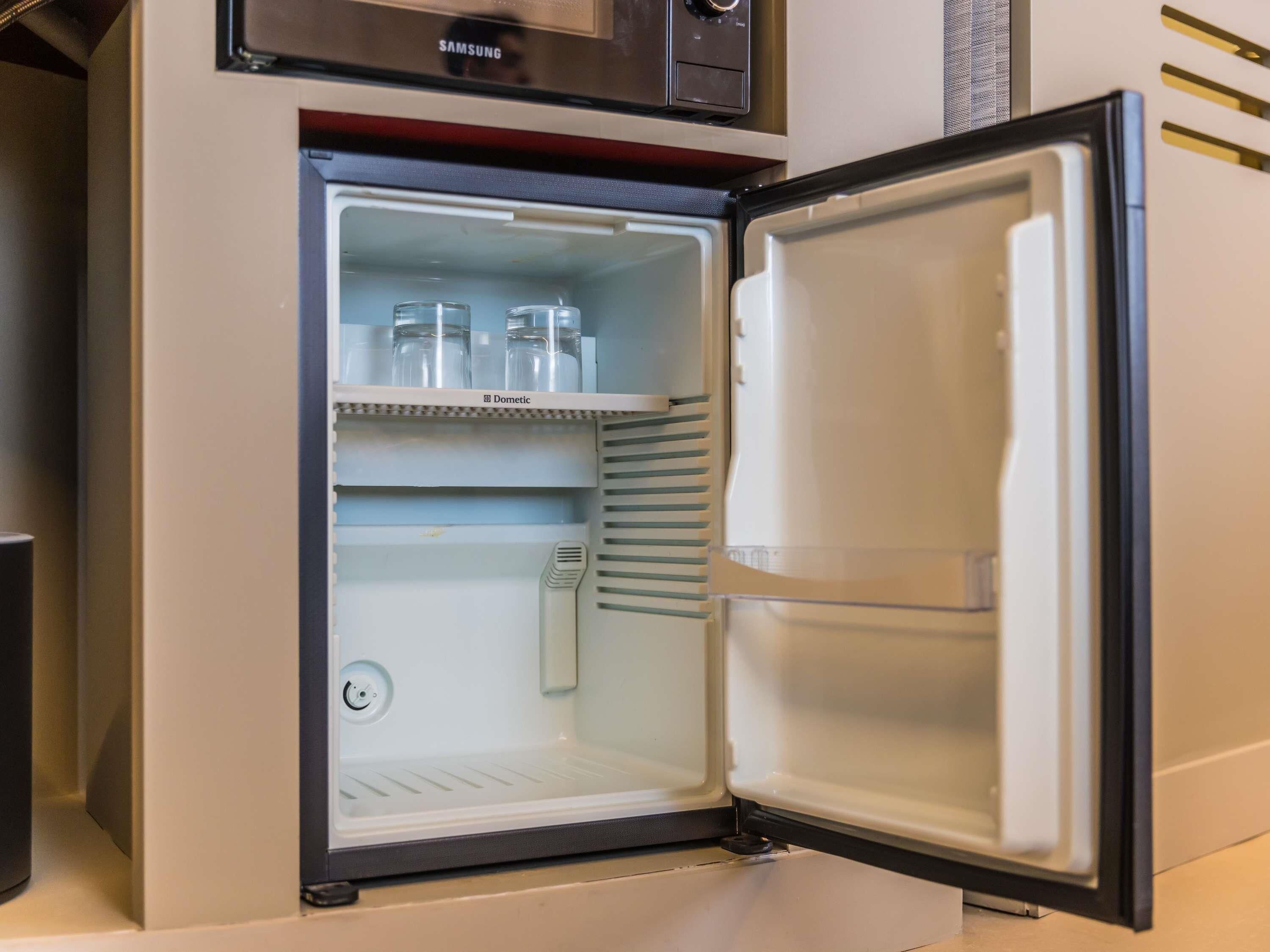 An open refrigerator with shelves and a freezer compartment.