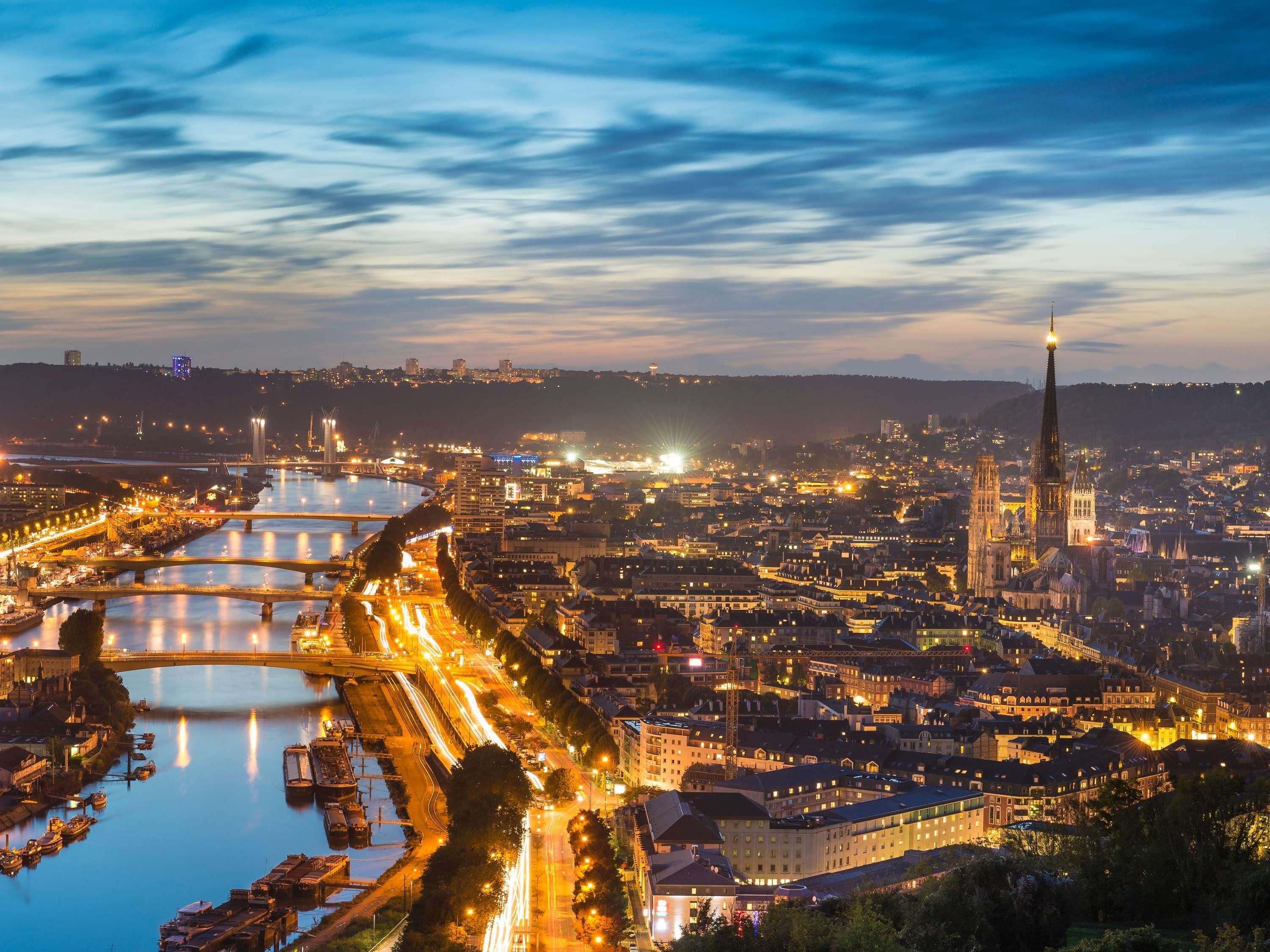 A cityscape with a prominent cathedral, a river with bridges, and a well-lit waterfront area.