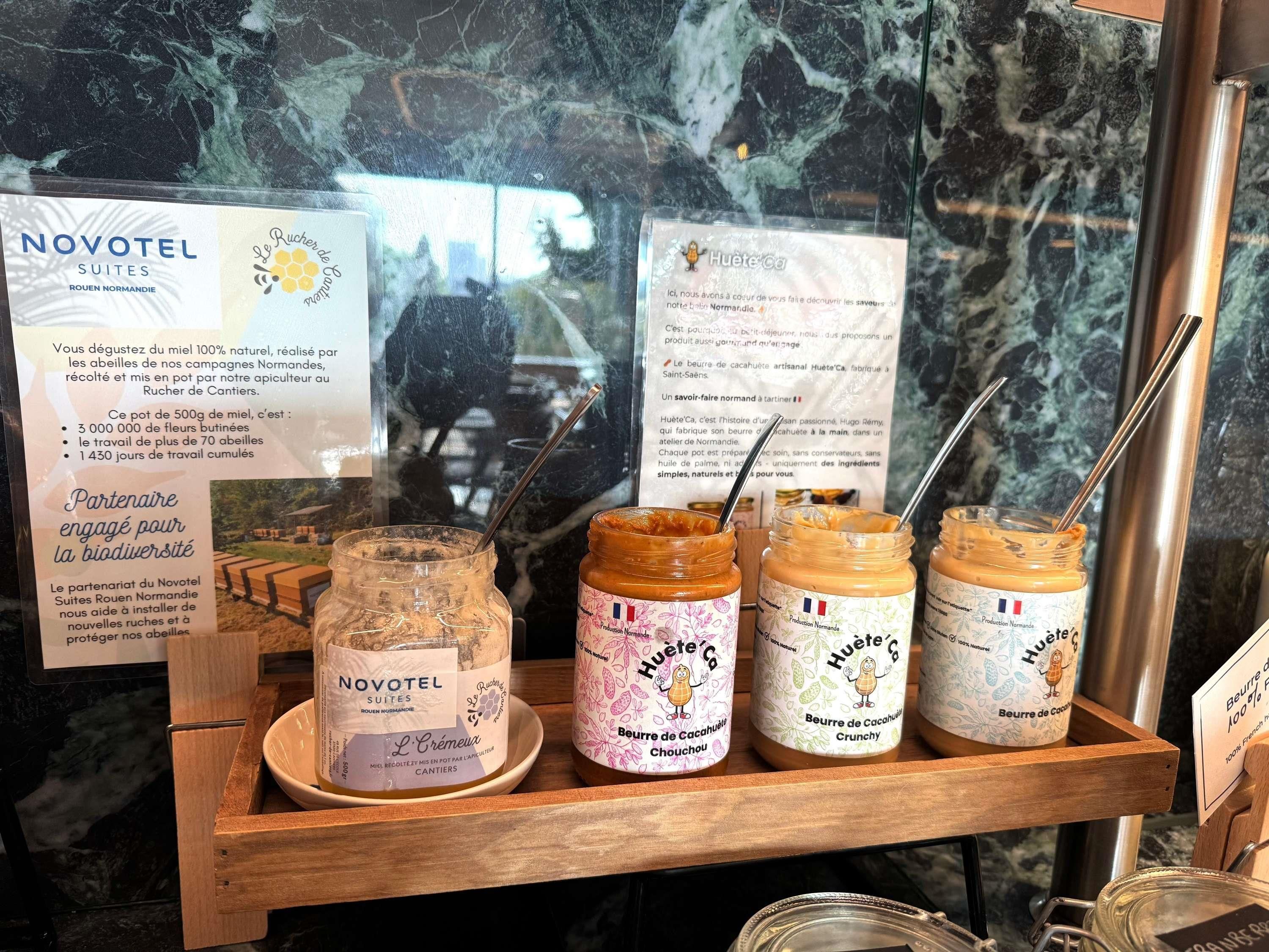 A display of Novotel Suites Rouen Normandie products including honey, cream, and chocolate spreads.