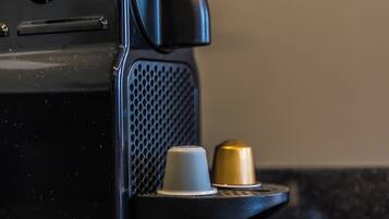 A black coffee machine with a handle, a small cup holder, and a brand name 'RESSO' on the side.