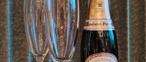 Une bouteille de champagne La Cuvée et deux verres vides.