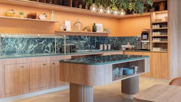 A modern kitchen with a marble countertop, wooden cabinets, and a central island.