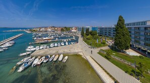 Ein Yachthafen mit angestaubten Booten, einer Promenade und modernen Gebäuden.